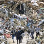 People walk through the rubble in Rikuzentakakata, Iwate Prefecture