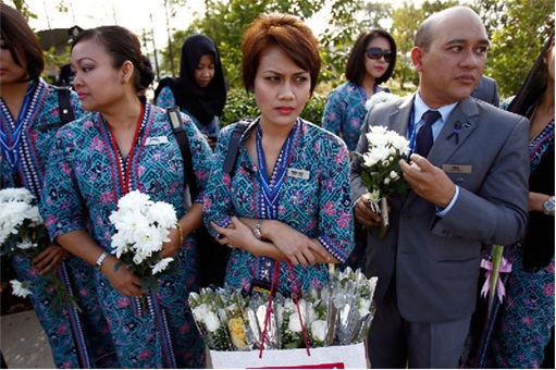 Malaysian Flight MH17 Victims Return Home - MAS staff holding flowers