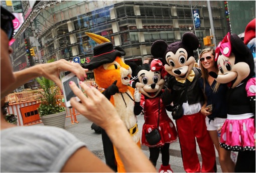 Mickey and Minnie Mouse taking photo with tourist