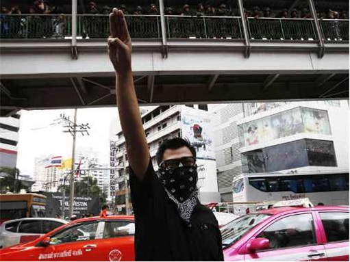 Thai Protesters with Three-Finger Salute in front of overhead bridge