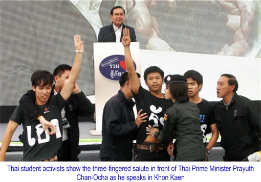 Thai student activists show the three-fingered salute in front of Thai Prime Minister Prayuth Chan-Ocha