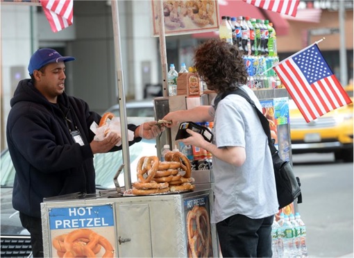 New York Ground Zero Hot Dog Stall - Ahmed Mohammed Selling Pretzel to Customer