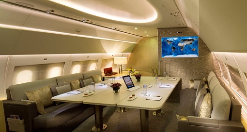 Emirates Airbus A319 Private Jet - Lounge Area- two large couches, four tables, and two 42-inch HD LCD screens