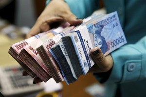 indonesian-currency-holding-stacks-of-rupiah-notes