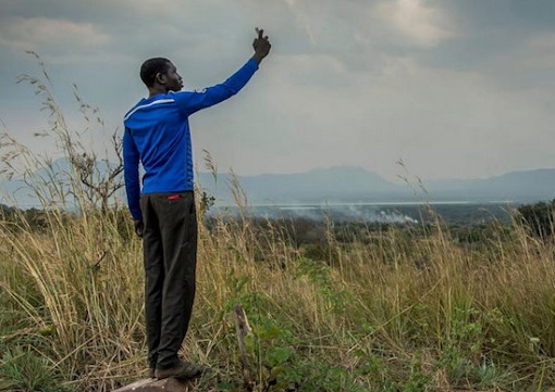 An African Refugee Tries To Get Cell Phone Signal