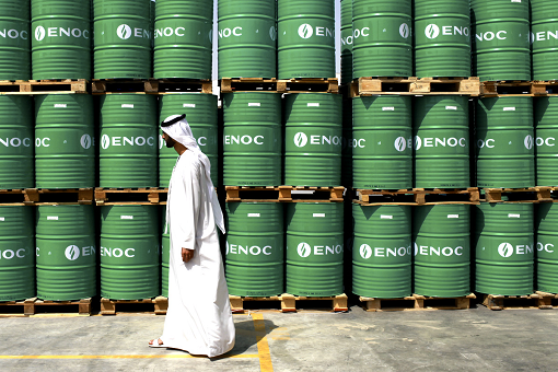 Saudi Walking Passing Barrels of Oil