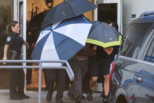 Bolsonaro and His Family Shielded by Umbrellas